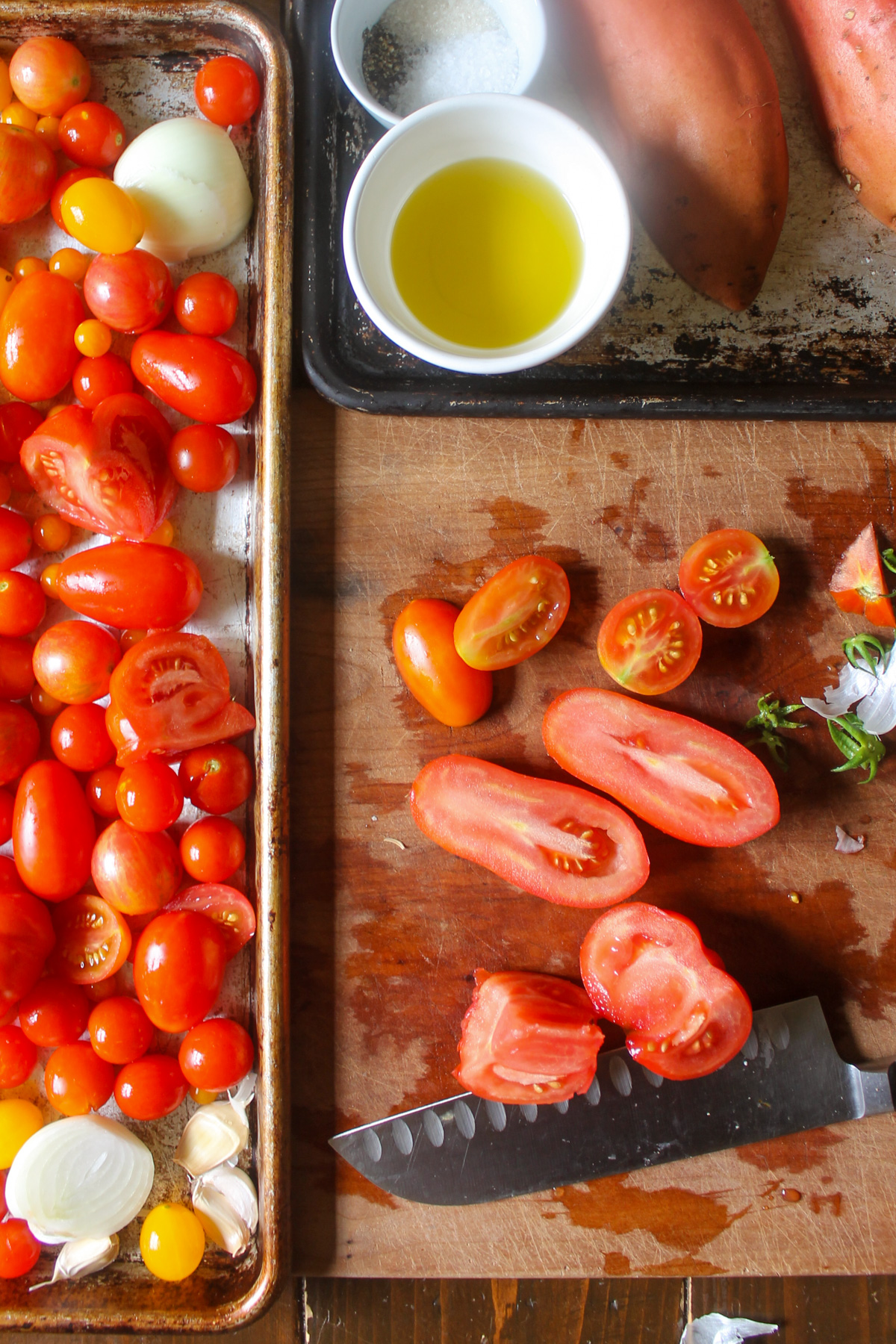 Cutting tomatoes in half on a cutting board.