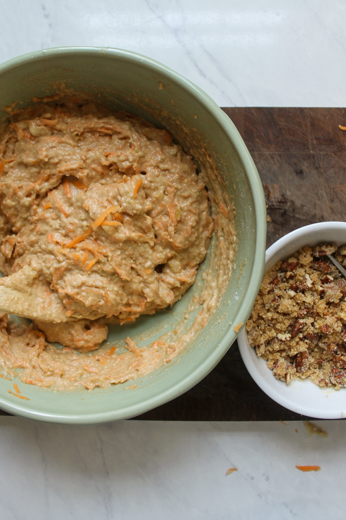 Carrot Applesauce Muffin batter in a bowl with a small bowl of streusel topping.